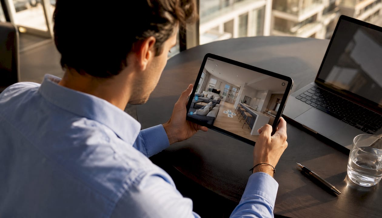 Mani che tengono un tablet mentre si visita una casa virtualmente